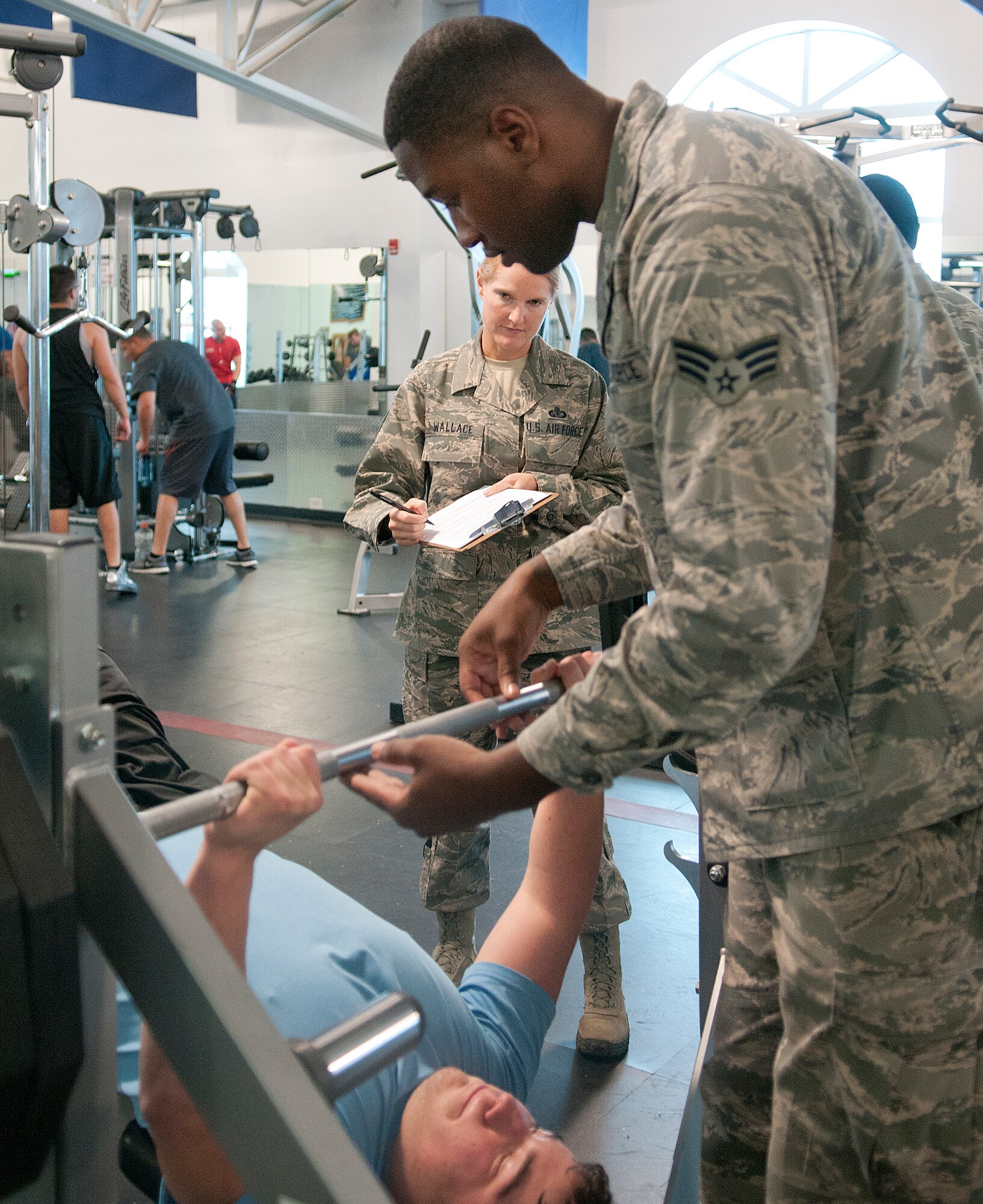 131121-F-JW079-067
Senior Airman William Shelby, 90th Force Support Squadron fitness specialist, spots Trenton Curtis as he uses the bench press while the watchful eye of Master Sgt. Tracy Wallace, 90th Maintenance Group first sergeant, observes his form in the Freedom Hall Fitness Center Nov. 21. Wallace was one of the people judging the fitness center’s Fitness Specialist Challenge, which Shelby was competing in. Shelby and his teammate, Senior Airmen Mark Currell, won the specialists competition. (U.S. Air Force photo by R.J. Oriez)
