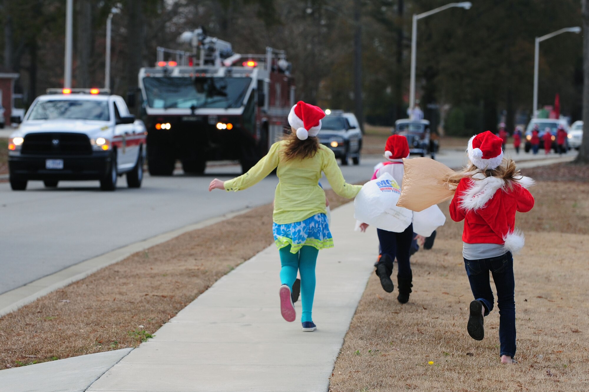 Children run to see a holiday parade at Seymour Johnson Air Force Base, N.C., Dec. 1, 2013. More than five base organizations participated in the parade to raise spirits during the holiday season. (U.S. Air Force photo by Airman 1st Class John Nieves Camacho)