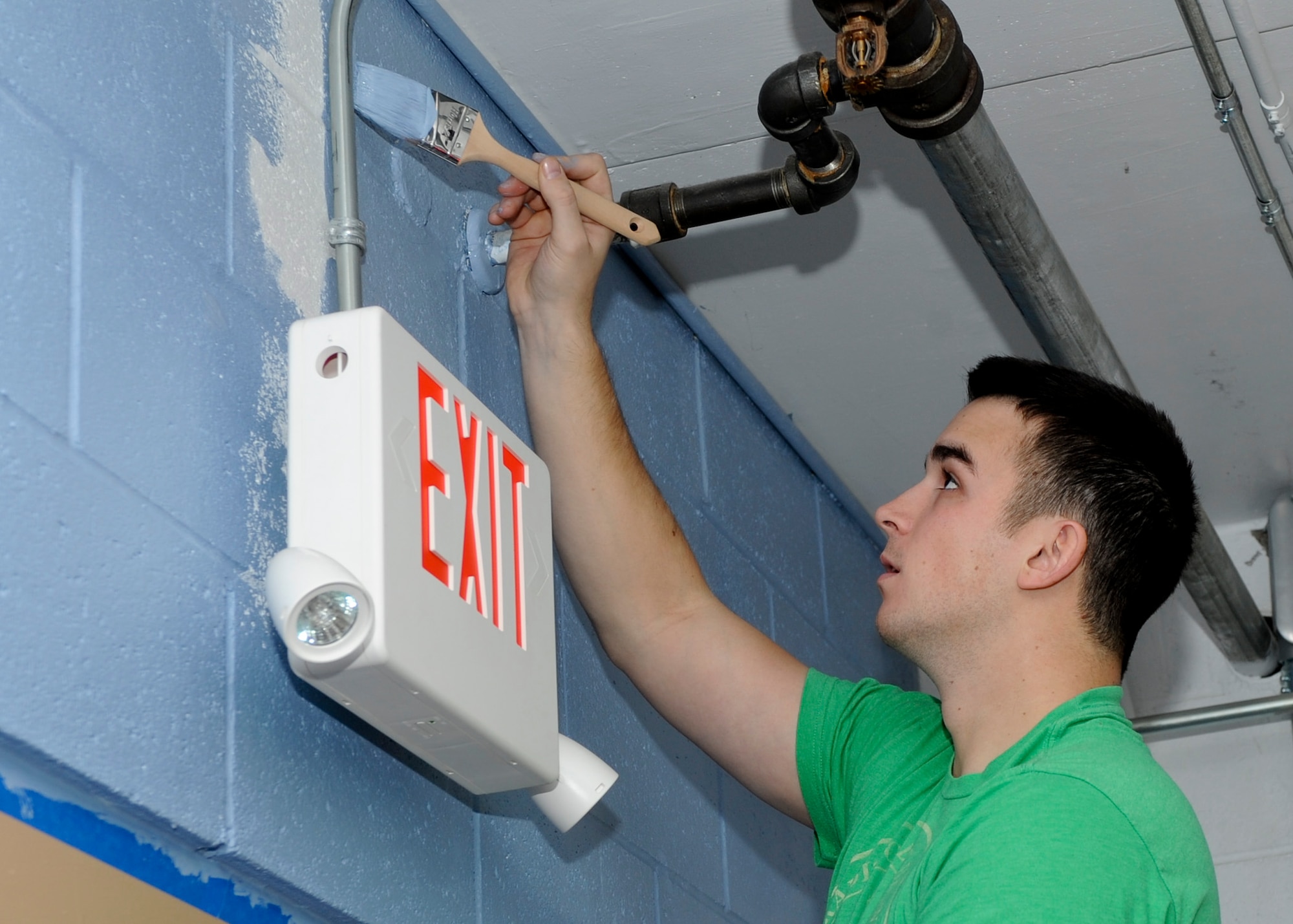 Senior Airman Joshua Stainbrook, 28th Security Forces Squadron NCO in charge of supplies, paints a wall during an Airman Leadership School community service project in the B-ONE Yard Thrift and Consignment store at Ellsworth Air Force Base, S.D., Nov. 23, 2013. While its primary purpose is to function as a non-profit thrift shop, the B-ONE Yard also offers various programs designed to provide savings for active duty servicemembers and their families. (U.S. Air Force photo by Senior Airman Anania Tekurio/Released)