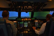 Lt. Col. James Bishop, 439th Airlift Wing Public Affairs Officer, and SMSgt. Gary Smith, 337th Airlift Squadron Flight Saftey, discuss the capabilities of the C-5 simulator inside the Base Hangar at Westover Air Reserve Base, Mass., Feb. 11, 2013. (U.S. Air Force photo/SrA. Kelly Galloway)