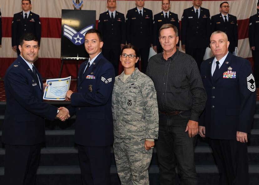 Senior Airman Nolan Petty II, 2nd Security Forces Squadron, receives a certificate of promotion from Col. Andrew Gebara, 2nd Bomb Wing commander, and Chief Master Sgt. Beau Markin, 2nd Maintenance Group, during the November Wing Promotion Ceremony on Barksdale Air Force Base, La., Nov. 27, 2013. (U.S. Air Force photo/Senior Airman Joseph A. Pagán Jr.)