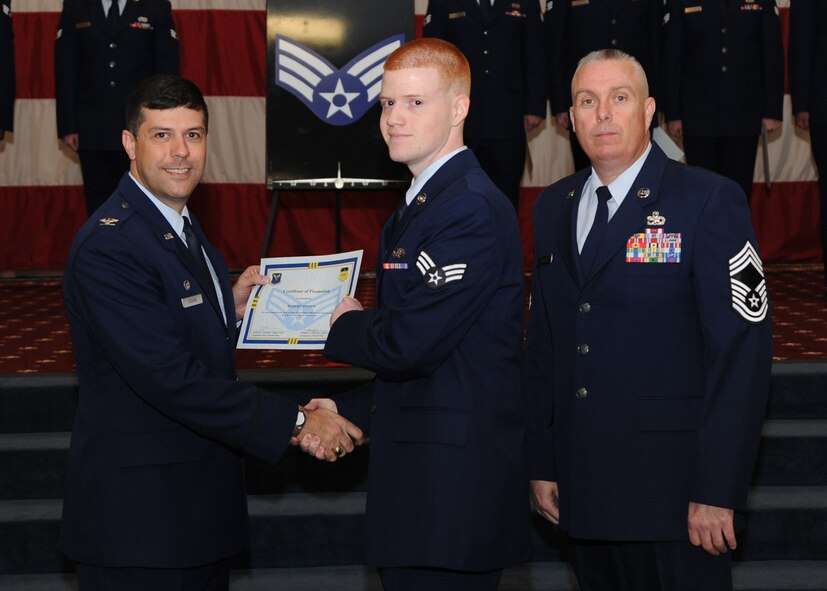 Senior Airman Robert Woten, 2nd Operations Support Squadron, receives a certificate of promotion from Col. Andrew Gebara, 2nd Bomb Wing commander, and Chief Master Sgt. Beau Markin, 2nd Maintenance Group, during the November Wing Promotion Ceremony on Barksdale Air Force Base, La., Nov. 27, 2013. (U.S. Air Force photo/Senior Airman Joseph A. Pagán Jr.)