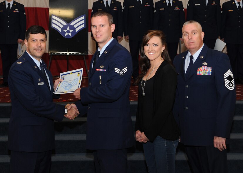 Senior Airman Wesley Pavlicek, 2nd Munitions Squadron, receives a certificate of promotion from Col. Andrew Gebara, 2nd Bomb Wing commander, and Chief Master Sgt. Beau Markin, 2nd Maintenance Group, during the November Wing Promotion Ceremony on Barksdale Air Force Base, La., Nov. 27, 2013. (U.S. Air Force photo/Senior Airman Joseph A. Pagán Jr.)