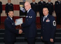 Senior Airman Ian Dellechiaie, 2nd Munitions Squadron, receives a certificate of promotion from Col. Andrew Gebara, 2nd Bomb Wing commander, and Chief Master Sgt. Beau Markin, 2nd Maintenance Group, during the November Wing Promotion Ceremony on Barksdale Air Force Base, La., Nov. 27, 2013. (U.S. Air Force photo/Senior Airman Joseph A. Pagán Jr.)