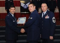 Senior Airman Eric Arellano, 2nd Munitions Squadron, receives a certificate of promotion from Col. Andrew Gebara, 2nd Bomb Wing commander, and Chief Master Sgt. Beau Markin, 2nd Maintenance Group, during the November Wing Promotion Ceremony on Barksdale Air Force Base, La., Nov. 27, 2013. (U.S. Air Force photo/Senior Airman Joseph A. Pagán Jr.)