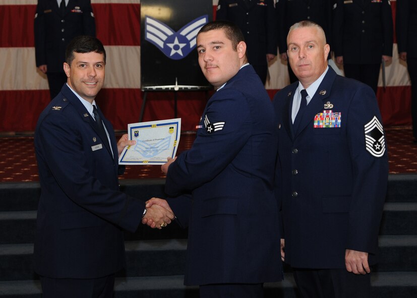 Senior Airman Eric Arellano, 2nd Munitions Squadron, receives a certificate of promotion from Col. Andrew Gebara, 2nd Bomb Wing commander, and Chief Master Sgt. Beau Markin, 2nd Maintenance Group, during the November Wing Promotion Ceremony on Barksdale Air Force Base, La., Nov. 27, 2013. (U.S. Air Force photo/Senior Airman Joseph A. Pagán Jr.)