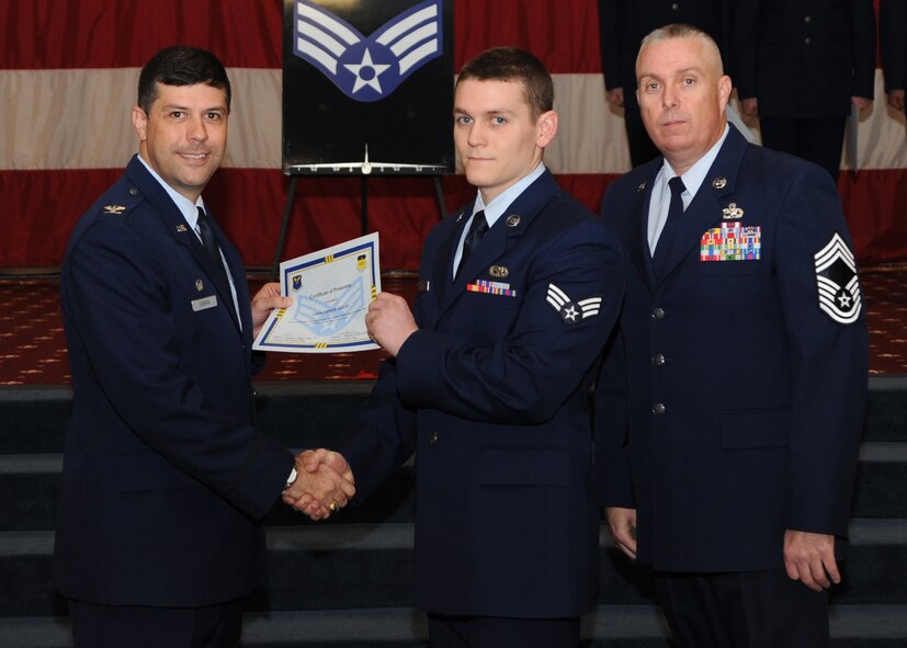 Senior Airman Christopher Shelby, 2nd Maintenance Squadron, receives a certificate of promotion from Col. Andrew Gebara, 2nd Bomb Wing commander, and Chief Master Sgt. Beau Markin, 2nd Maintenance Group, during the November Wing Promotion Ceremony on Barksdale Air Force Base, La., Nov. 27, 2013. (U.S. Air Force photo/Senior Airman Joseph A. Pagán Jr.)