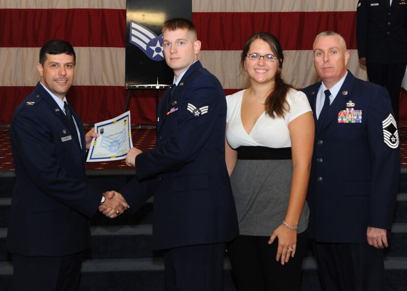 Senior Airman John Mayfield, 2nd Maintenance Squadron, receives a certificate of promotion from Col. Andrew Gebara, 2nd Bomb Wing commander, and Chief Master Sgt. Beau Markin, 2nd Maintenance Group, during the November Wing Promotion Ceremony on Barksdale Air Force Base, La., Nov. 27, 2013. (U.S. Air Force photo/Senior Airman Joseph A. Pagán Jr.)
