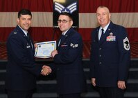 Senior Airman Michael Herrera, 2nd Maintenance Squadron, receives a certificate of promotion from Col. Andrew Gebara, 2nd Bomb Wing commander, and Chief Master Sgt. Beau Markin, 2nd Maintenance Group, during the November Wing Promotion Ceremony on Barksdale Air Force Base, La., Nov. 27, 2013. (U.S. Air Force photo/Senior Airman Joseph A. Pagán Jr.)