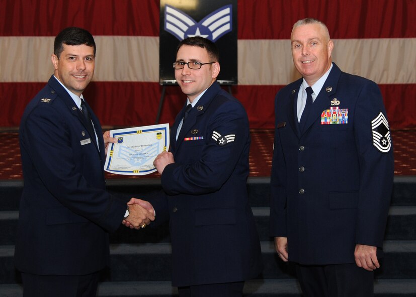 Senior Airman Michael Herrera, 2nd Maintenance Squadron, receives a certificate of promotion from Col. Andrew Gebara, 2nd Bomb Wing commander, and Chief Master Sgt. Beau Markin, 2nd Maintenance Group, during the November Wing Promotion Ceremony on Barksdale Air Force Base, La., Nov. 27, 2013. (U.S. Air Force photo/Senior Airman Joseph A. Pagán Jr.)