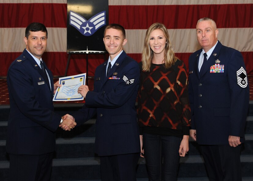 Senior Airman Shane Rosenberry, 2nd Communications Squadron, receives a certificate of promotion from Col. Andrew Gebara, 2nd Bomb Wing commander, and Chief Master Sgt. Beau Markin, 2nd Maintenance Group, during the November Wing Promotion Ceremony on Barksdale Air Force Base, La., Nov. 27, 2013. (U.S. Air Force photo/Senior Airman Joseph A. Pagán Jr.)