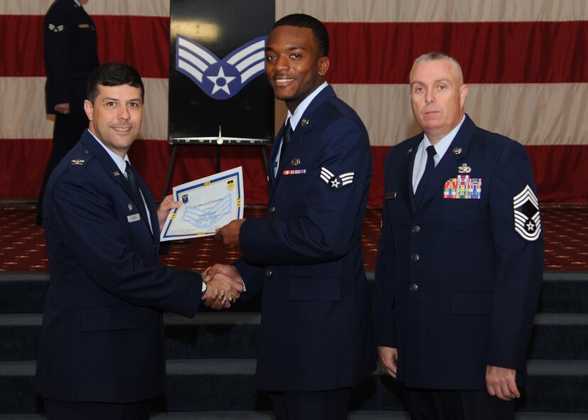 Senior Airman James Yallery, 2nd Aircraft Maintenance Squadron, receives a certificate of promotion from Col. Andrew Gebara, 2nd Bomb Wing commander, and Chief Master Sgt. Beau Markin, 2nd Maintenance Group, during the November Wing Promotion Ceremony on Barksdale Air Force Base, La., Nov. 27, 2013. (U.S. Air Force photo/Senior Airman Joseph A. Pagán Jr.)