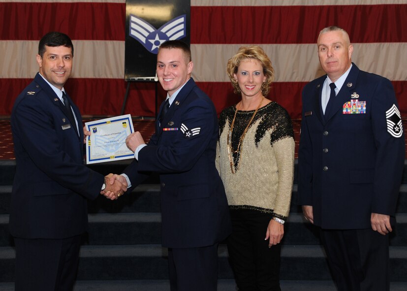 Senior Airman Tyler Berthelot, 2nd Aircraft Maintenance Squadron, receives a certificate of promotion from Col. Andrew Gebara, 2nd Bomb Wing commander, and Chief Master Sgt. Beau Markin, 2nd Maintenance Group, during the November Wing Promotion Ceremony on Barksdale Air Force Base, La., Nov. 27, 2013. (U.S. Air Force photo/Senior Airman Joseph A. Pagán Jr.)