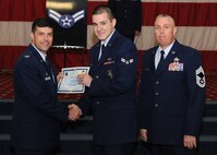 Airman 1st Class Brian Pugh, 2nd Security Forces Squadron, receives a certificate of promotion from Col. Andrew Gebara, 2nd Bomb Wing commander, and Chief Master Sgt. Beau Markin, 2nd Maintenance Group, during the November Wing Promotion Ceremony on Barksdale Air Force Base, La., Nov. 27, 2013. (U.S. Air Force photo/Senior Airman Joseph A. Pagán Jr.)
