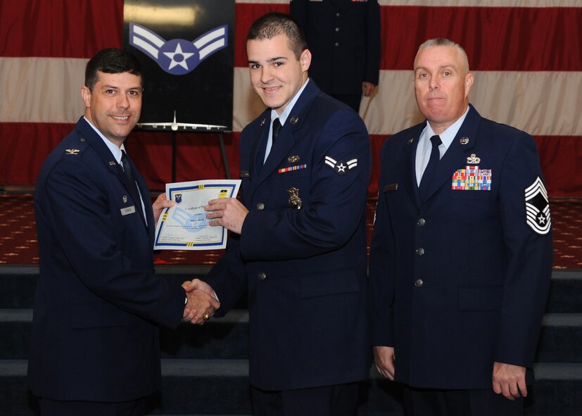 Airman 1st Class Brian Pugh, 2nd Security Forces Squadron, receives a certificate of promotion from Col. Andrew Gebara, 2nd Bomb Wing commander, and Chief Master Sgt. Beau Markin, 2nd Maintenance Group, during the November Wing Promotion Ceremony on Barksdale Air Force Base, La., Nov. 27, 2013. (U.S. Air Force photo/Senior Airman Joseph A. Pagán Jr.)