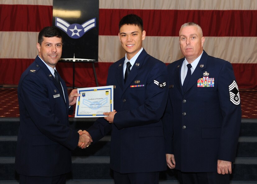 Airman 1st Class Andrew Dawson Jr., 2nd Communications Squadron, receives a certificate of promotion from Col. Andrew Gebara, 2nd Bomb Wing commander, and Chief Master Sgt. Beau Markin, 2nd Maintenance Group, during the November Wing Promotion Ceremony on Barksdale Air Force Base, La., Nov. 27, 2013. (U.S. Air Force photo/Senior Airman Joseph A. Pagán Jr.)