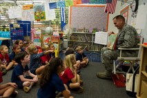 Col. Johnny Roscoe, 15th Wing commander, reads a favorite childhood book, The Big Hungry Bear, to a kindergarten class at Hickam Elementary School on Joint Base Pearl Harbor-Hickam, Hawaii, Dec. 2, 2013. Roscoe’s visit to the school was part of the weekly Rockin’ Reader program which invites volunteers to the school for story time with the children. (U.S. Air Force photo/Staff Sgt. Terri Paden)