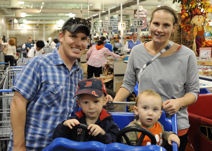 Staff Sgt. Bryan Johnson, 26th Operational Weather Squadron, poses with his spouse and children at the Commissary on Barksdale Air Force Base, La., Nov 20, 2013. First sergeants surprised Johnson and his family with gift cards as part of a Random Act of Kindness to assist families during the holidays. (U.S. Air Force photo/Senior Airman Joseph A. Pagán Jr.)