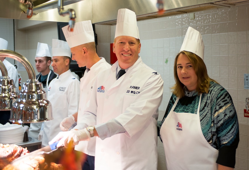 U.S. Air Force Col. Steven Ramer, center, 23d Wing vice commander, poses while slicing turkey with his wife Anne at the start of a serving line at Moody Air Force Base, Ga., Nov. 28, 2013. Airmen were offered the traditional Thanksgiving spread and a variety of desserts. (U.S. Air Force photo by Airman 1st Class Ryan Callaghan/Released)
