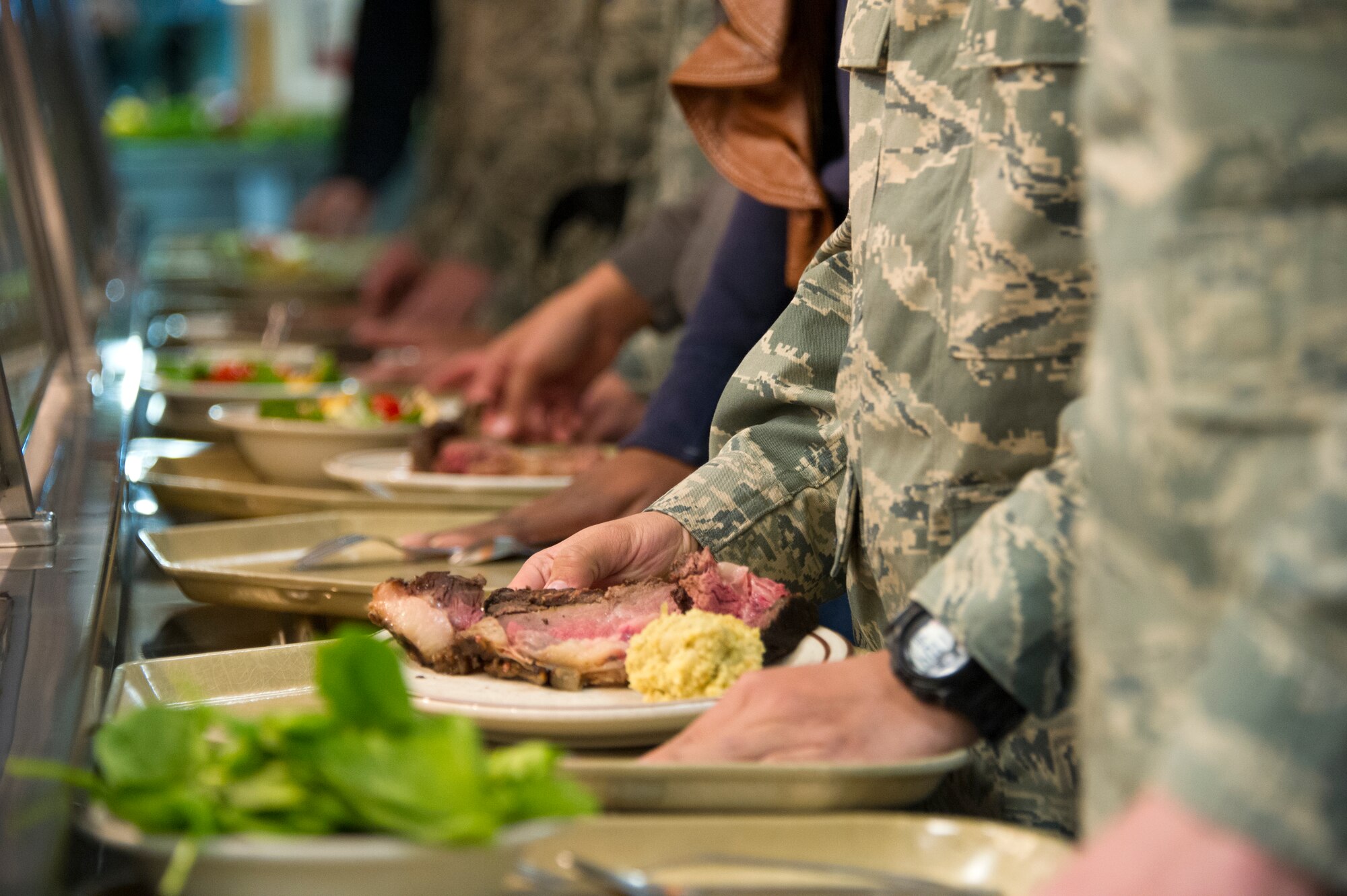 Airmen advance in a serving line during Thanksgiving lunch Nov. 28, 2013, at the Azalea Dining Facility, Keesler Air Force Base, Miss.  Wing leadership continued a Keesler annual tradition by serving food to Airmen for the holiday. (U.S. Air Force photo by Adam Bond)