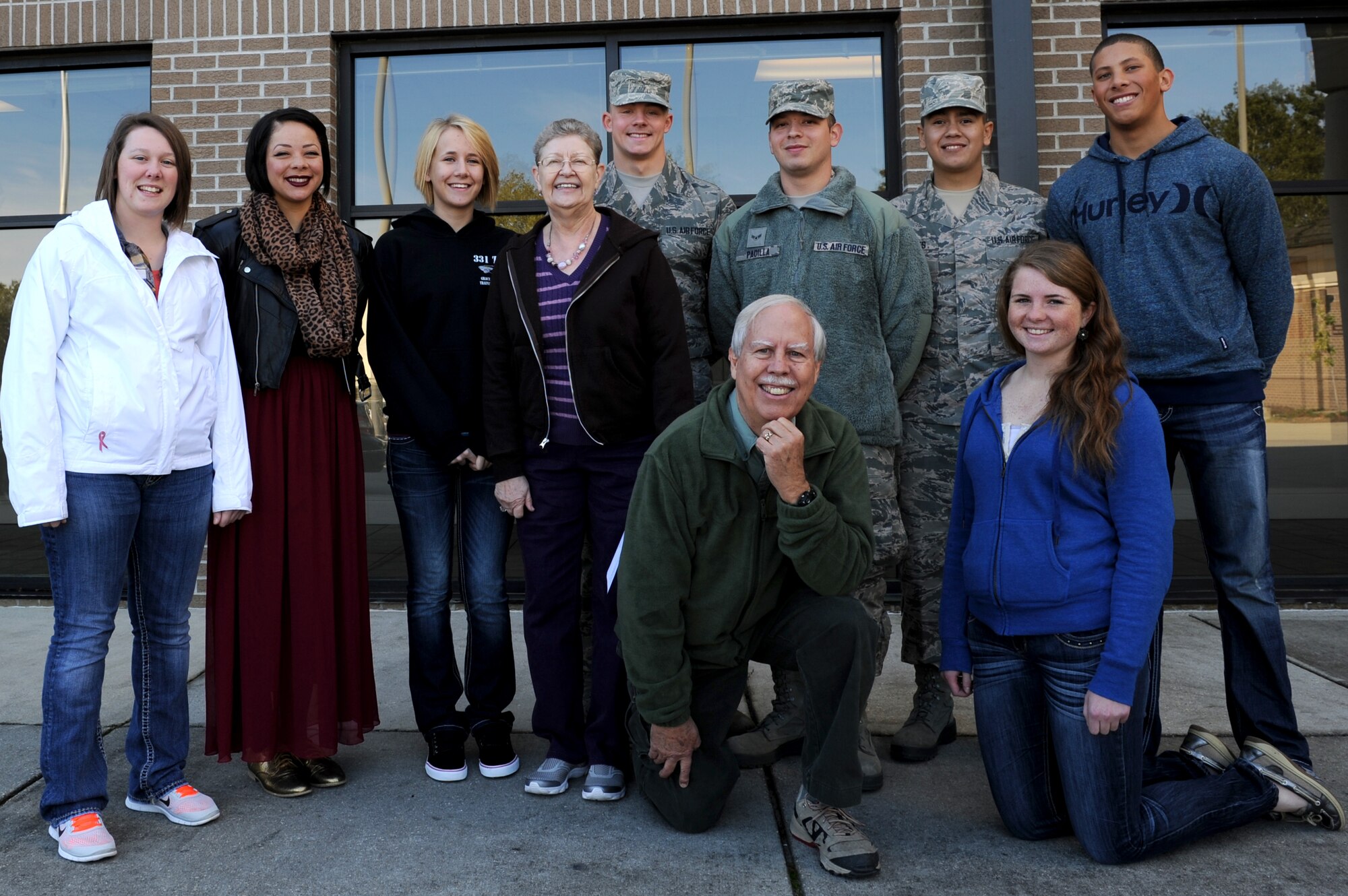 Irene McIntosh and Ed Cake pose for a group photo with the 81st Training Wing Airmen they are sponsoring for the “Home Away From Home” program, Keesler Air Force Base, Miss., Nov. 28, 2013.  The “Home Away From Home” is a program sponsored by the 81st Training Wing Chapel that allows Team Keesler and local residents to sponsor non-prior service Airmen who couldn’t make it home for Thanksgiving to enjoy a home cooked meal. This is Irene’s fifth year participating in the program.