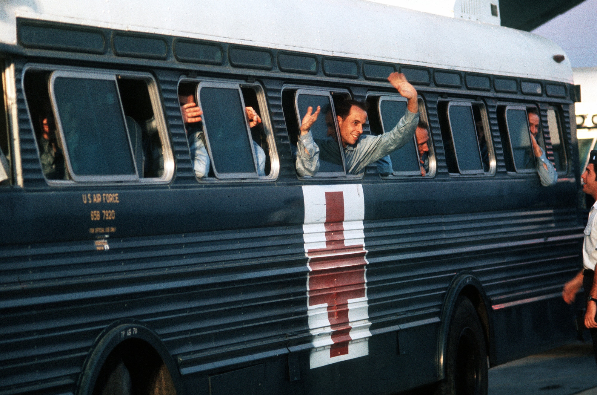 A returnee waves from a hospital bus at Clark Air Base shortly after being released from a prisoner of war camp in Vietnam. (DoD Photo)