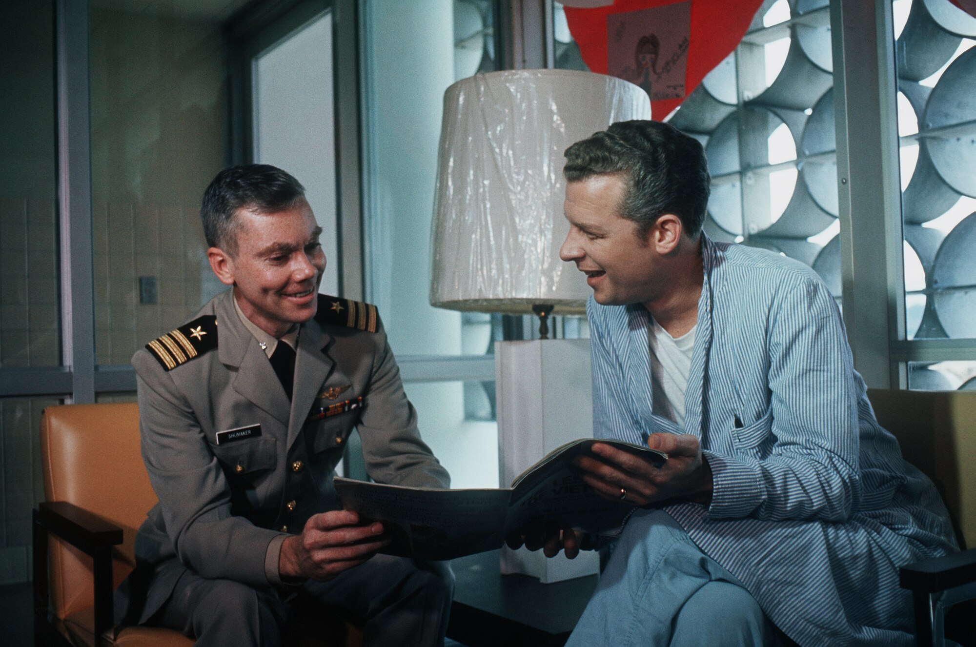 Former POW and U.S. Navy CMDR Robert Harper Shumaker (Captured 11 Feb 65) shares a magazine with fellow ex-POW U.S. Navy LCMDR Phillip Neal Butler (Captured 20 Apr 65) in the hospital reading lounge.  CMDR Shumaker and LCMDR Butler were released by the North Vietnamese in Hanoi on 12 Feb 73. (DoD Photo)