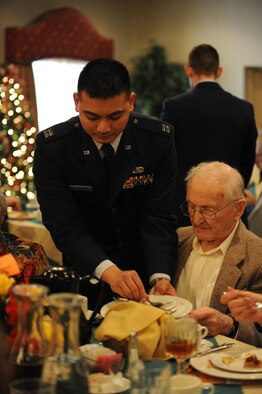 Capt. Carl Reyes, 5th Aircraft Maintenance Squadron, busses tableware during the Day of Love event at Minot Air Force Base, N.D., Nov. 28. The Thanksgiving Day tradition brings together Airmen and senior citizens from the Minot community in an afternoon of companionship and camaraderie. (U.S. Air Force photo/Senior Airman Jose L. Hernandez)
