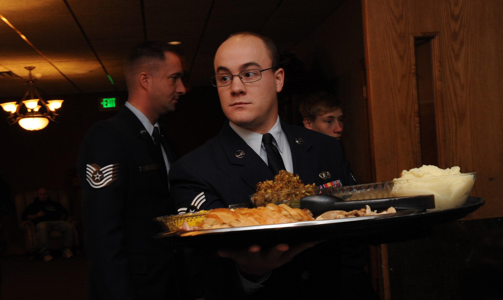 Senior Airman Christopher Francis, 5th Civil Engineer Squadron structures journeyman, prepares to serve a meal course to guests during the 44th annual Day of Love event at Minot Air Force Base, N.D., Nov. 28. The Thanksgiving Day event is a tradition where Airmen show their appreciation to the elderly of the Minot community by serving them lunch meals. (U.S. Air Force photo/Senior Airman Jose L. Hernandez)
