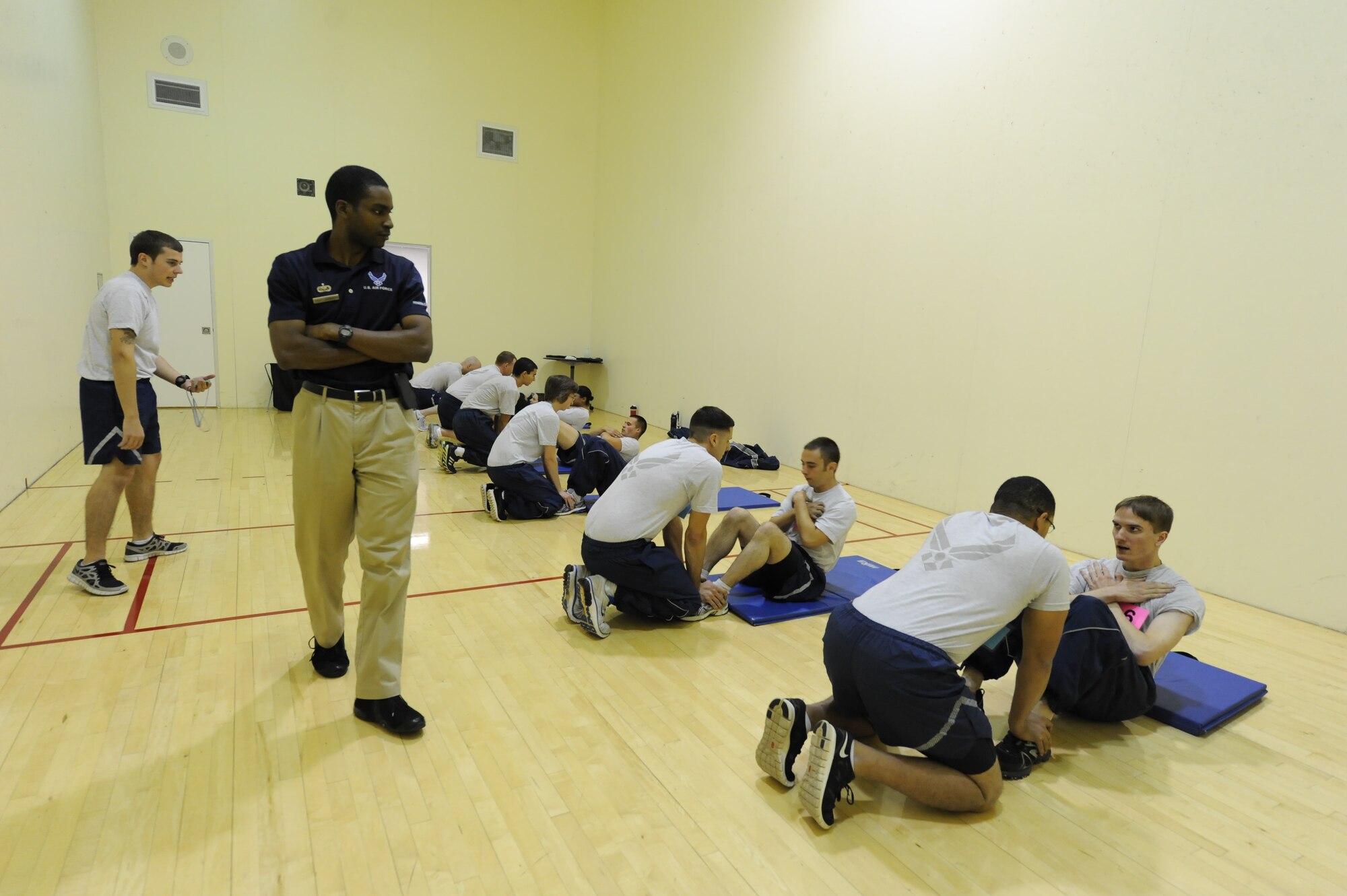 Staff Sgt. Kenneth Johnson II, 5th Force Support Squadron noncommissioned officer in charge of fitness assessment, observes the sit-up portion of a physical fitness test at Minot Air Force Base, N.D., Oct. 21. Johnson has worked as an Air Force personal trainer and member of the fitness staff for more than six years. (U.S. Air Force photo/Senior Airman Stephanie Sauberan)