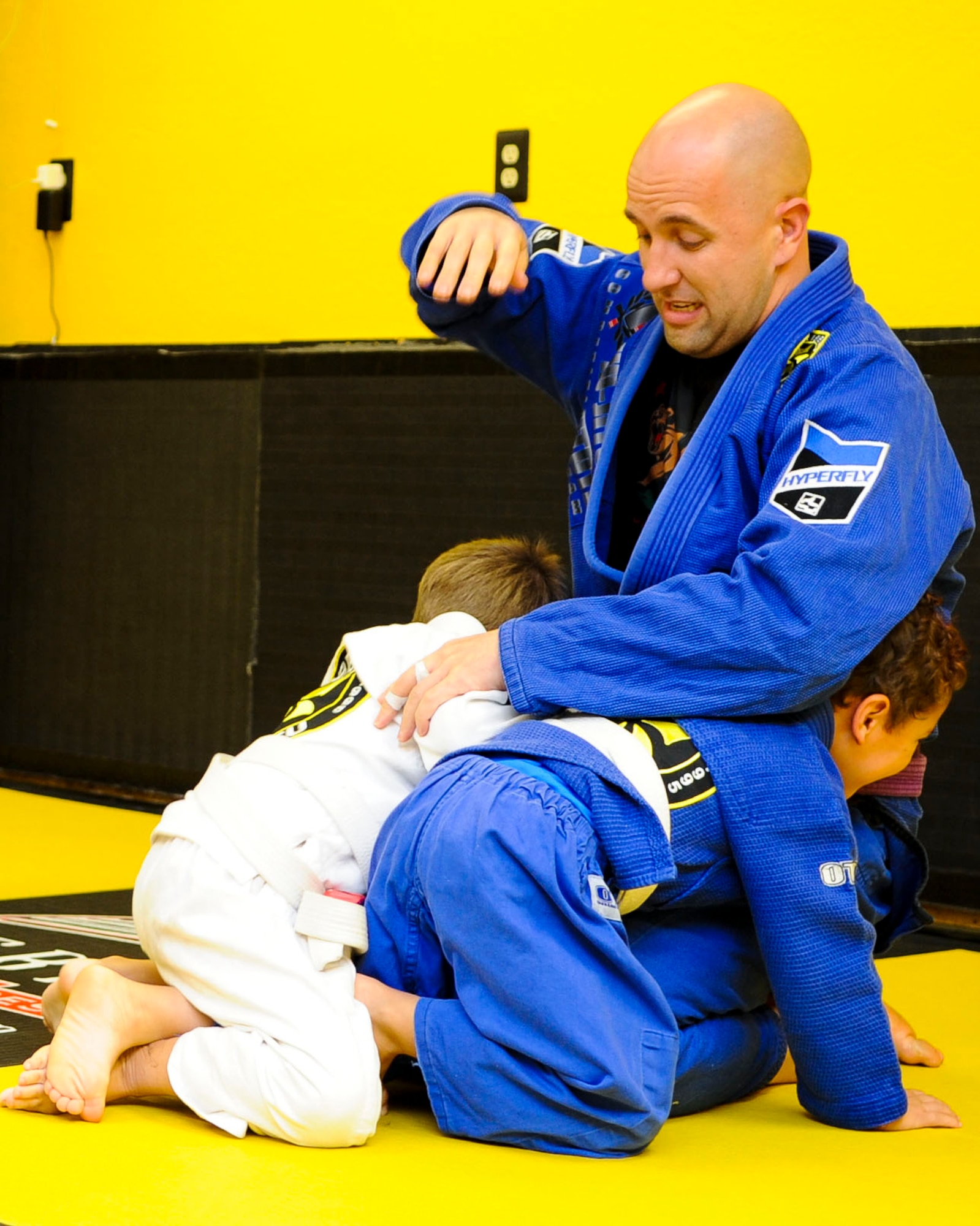 U.S. Army Staff Sgt. David Scott, Fort Eustis Modern Army Combatives Program instructor, plays with his son and another student before Brazilian jiu-jitsu class starts in Yorktown, Va., Nov. 21, 2013. Scott’s family life revolves around martial arts: his son participates in a BJJ class and his wife works as an administrator for the BJJ school. (U.S. Air Force photo by Airman 1st Class Austin Harvill/Released)