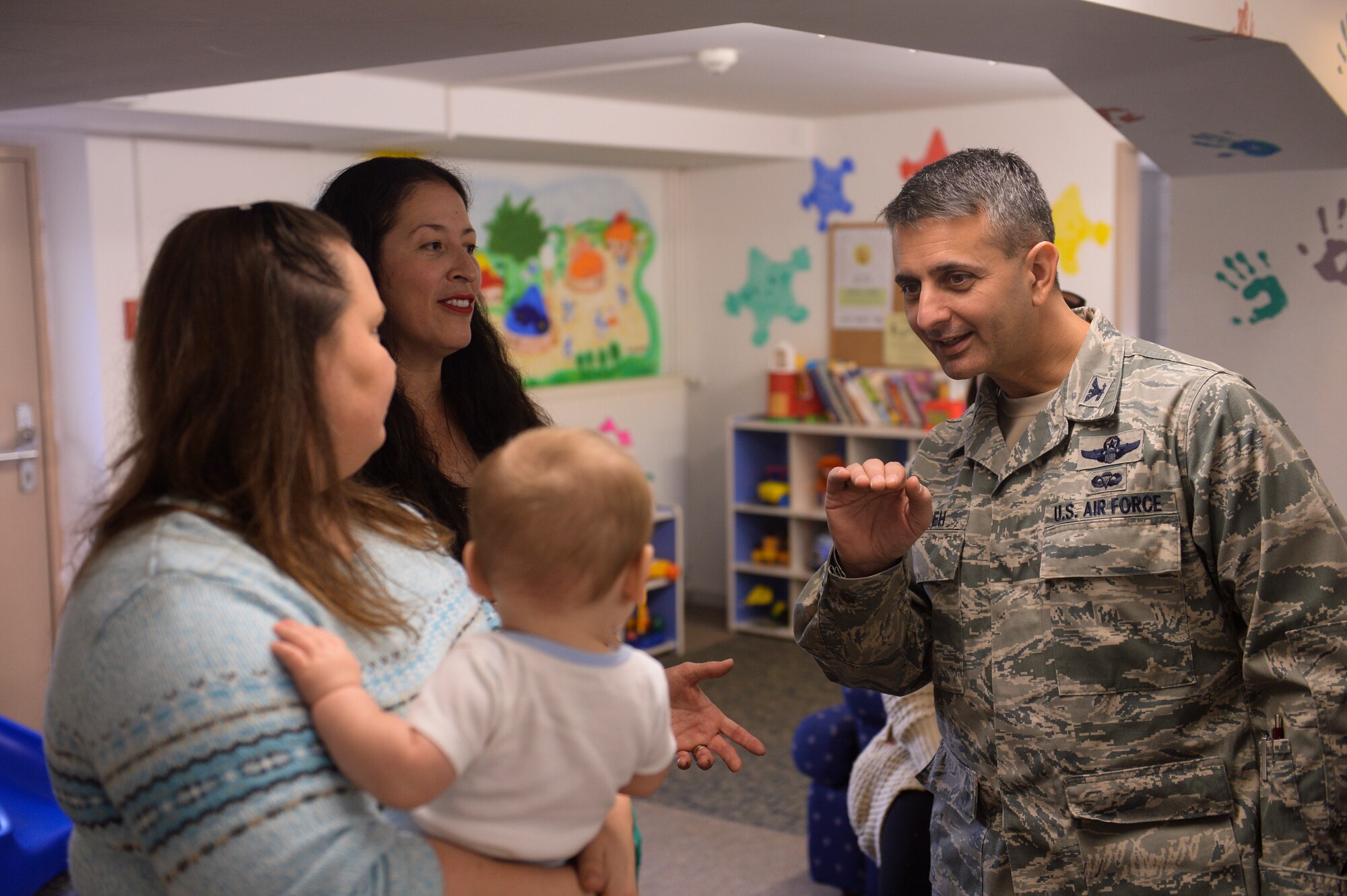 SPANGDAHLEM AIR BASE, Germany-- U.S. Air Force Col. David Julazadeh, 52nd Fighter Wing commander, waves to a child during a Family Advocacy Play Group meeting Dec. 3, 2013. The commander spoke with many families during the event. (U.S. Air Force photo by Senior Airman Rusty Frank/Released)