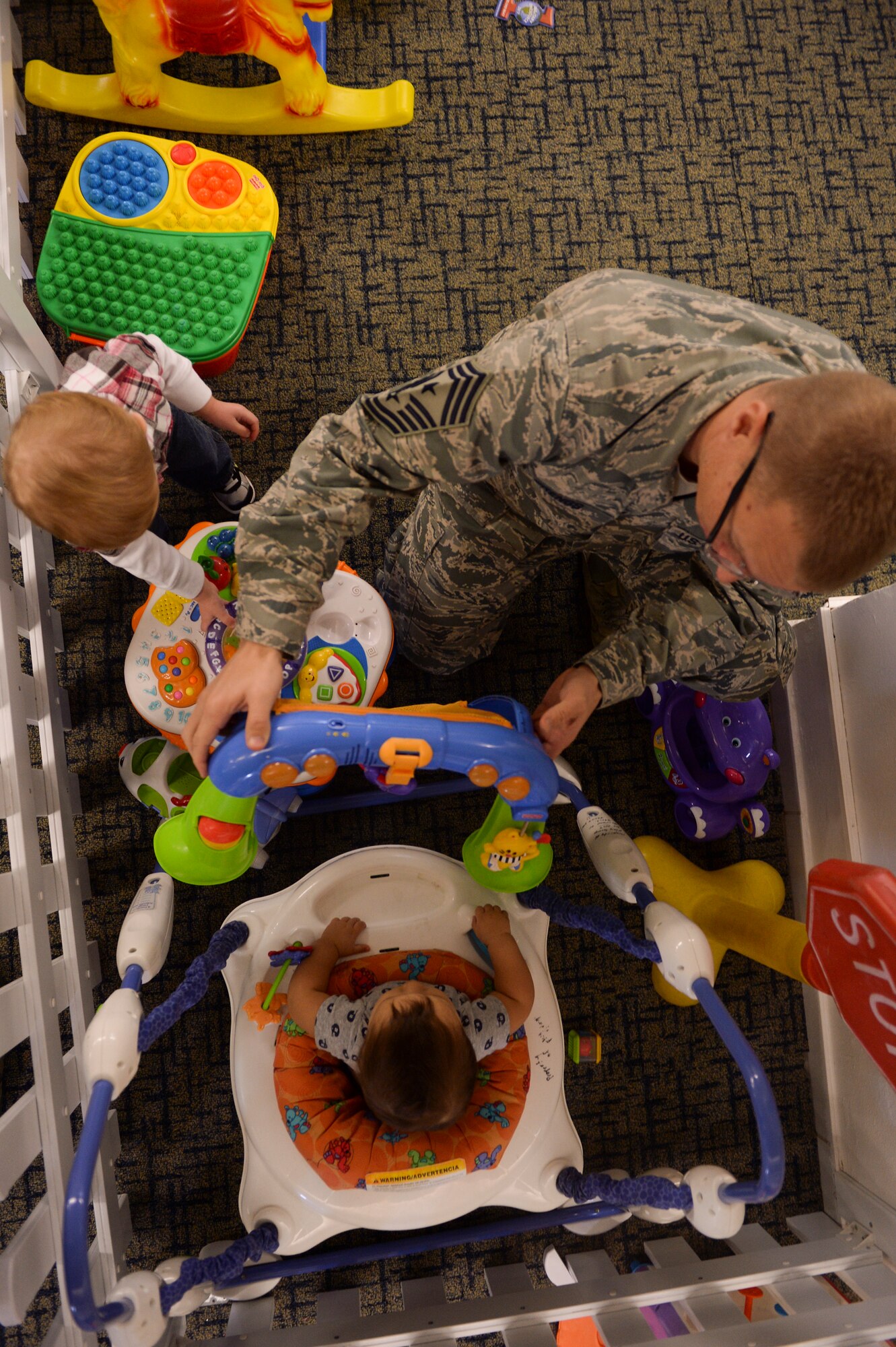SPANGDAHLEM AIR BASE, Germany-- U.S. Air Force Chief Master Sgt. Matthew Grengs, 52nd Fighter Wing command chief, plays with a child during a Family Advocacy Play Group meeting Dec. 3, 2013. Grengs and other members of 52nd FW leadership visited with group families during the meeting. (U.S. Air Force photo by Senior Airman Rusty Frank/Released)
