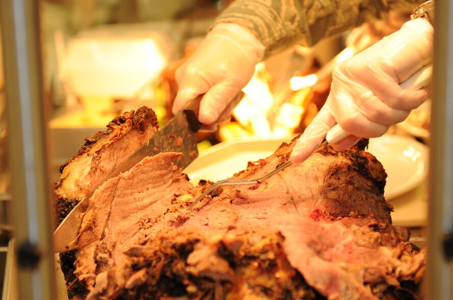 U.S. Air Force Col. Lamar Pettus, 4th Fighter Wing vice commander, slices into a 67-pound roast beef at The Southern Eagle Dining Facility at Seymour Johnson Air Force Base Nov. 28, 2013. Airmen who visited the DFAC had a choice between roast beef, ham, turkey or all three during a leadership-served Thanksgiving meal. (U.S. Air Force photo by Tech. Sgt. Phillip Butterfield)