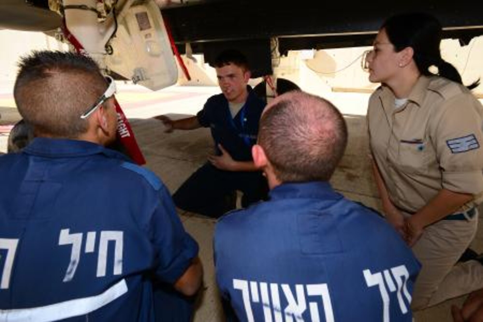 Airman 1st Class Jesse Hunt, 48th Aircraft Maintenance Squadron crew chief, talks with Israeli and Italian maintainers about the F-15E Strike Eagle during the Blue Flag exercise at Uvda Air Force Base, Israel, Nov. 26, 2013. Blue Flag was a multinational aerial warfare exercise hosted by Israel, which promoted improved operational capability, combat effectiveness, understanding and cooperation between the U.S., Israel, Greece, and Italy. The exercise was conducted from Nov. 24-28 and further strengthened the long-lasting relationship between the partner nations, while ensuring regional peace and stability. (U.S. Air Force photo by Master Sgt. Lee Osberry/Released)