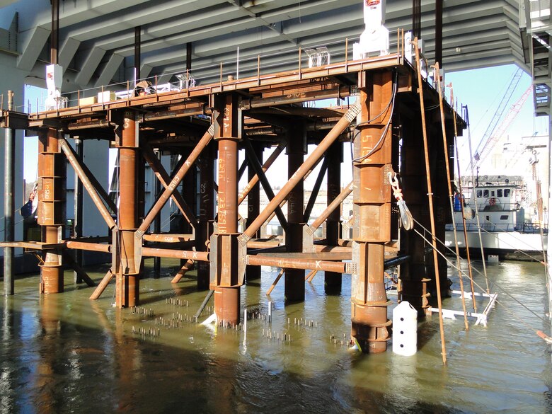 Still attached to the catamaran barge by the tubular lifting frame, Sill Shell No. 6 is lowered into place beneath the Ohio River Thanksgiving Day. The shell is part of the tainter gate section of the Olmsted Dam under construction between Illinois and Kentucky 17 miles upstream from the Mississippi River. The Olmsted Locks and Dam project will replace locks and dams 52 and 53 and greatly improve commercial navigation along the busiest stretch of water highway in the United States.           