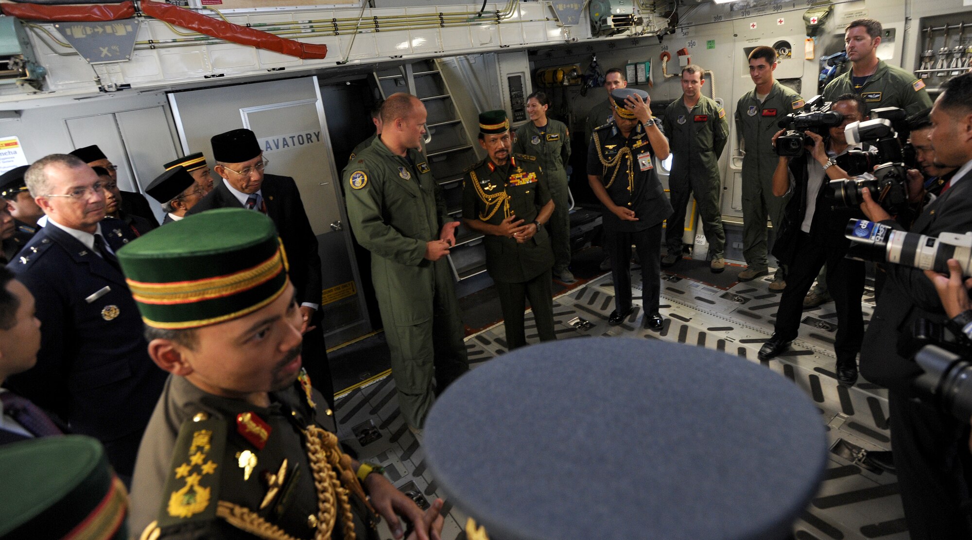 Maj. Chris Ross, Pacific Air Forces demonstration team copilot, center left, provides a guided tour aboard a C-17 Globemaster III to His Majesty Sultan Haji Hassanal Bolkiahsutan of Brunei, center right, and members of his entourage during the 4th biennial Brunei Darussalam International Defense Exhibition, at Rimba Air Base, Dec. 3, 2013. JBPPH personnel will be showcasing the C-17 through static displays and aerial demonstrations during BRIDEX. The exhibition is an opportunity for networking and sharing technology with regional partners and allies, building strong multilateral relationships, increased cooperation and enhanced preparedness for disasters and other contingency operations. (U.S. Air Force photo/Master Sgt. Jerome S. Tayborn)