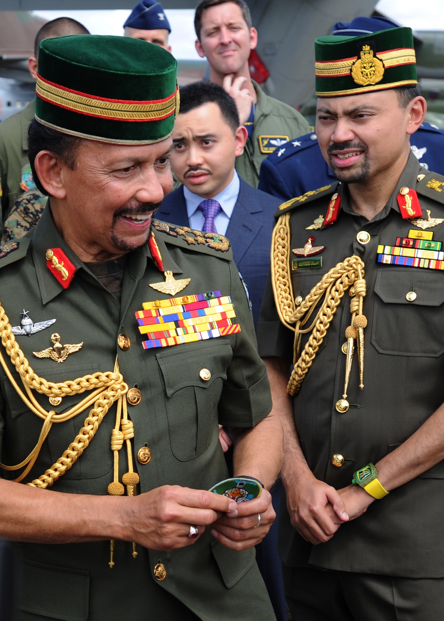 His Majesty Sultan Haji Hassanal Bolkiahsutan of Brunei, left, accepts a flight patch from a U.S. servicemember during the 4th biennial Brunei Darussalam International Defense Exhibition, on the flightline at Rimba Air Base, Dec. 3, 2013. BRIDEX 13 is an opportunity for networking and sharing technology with regional partners and allies, building strong multilateral relationships, increased cooperation and enhanced preparedness for disasters and other contingency operations. (U.S. Air Force photo/Master Sgt. Jerome S. Tayborn)