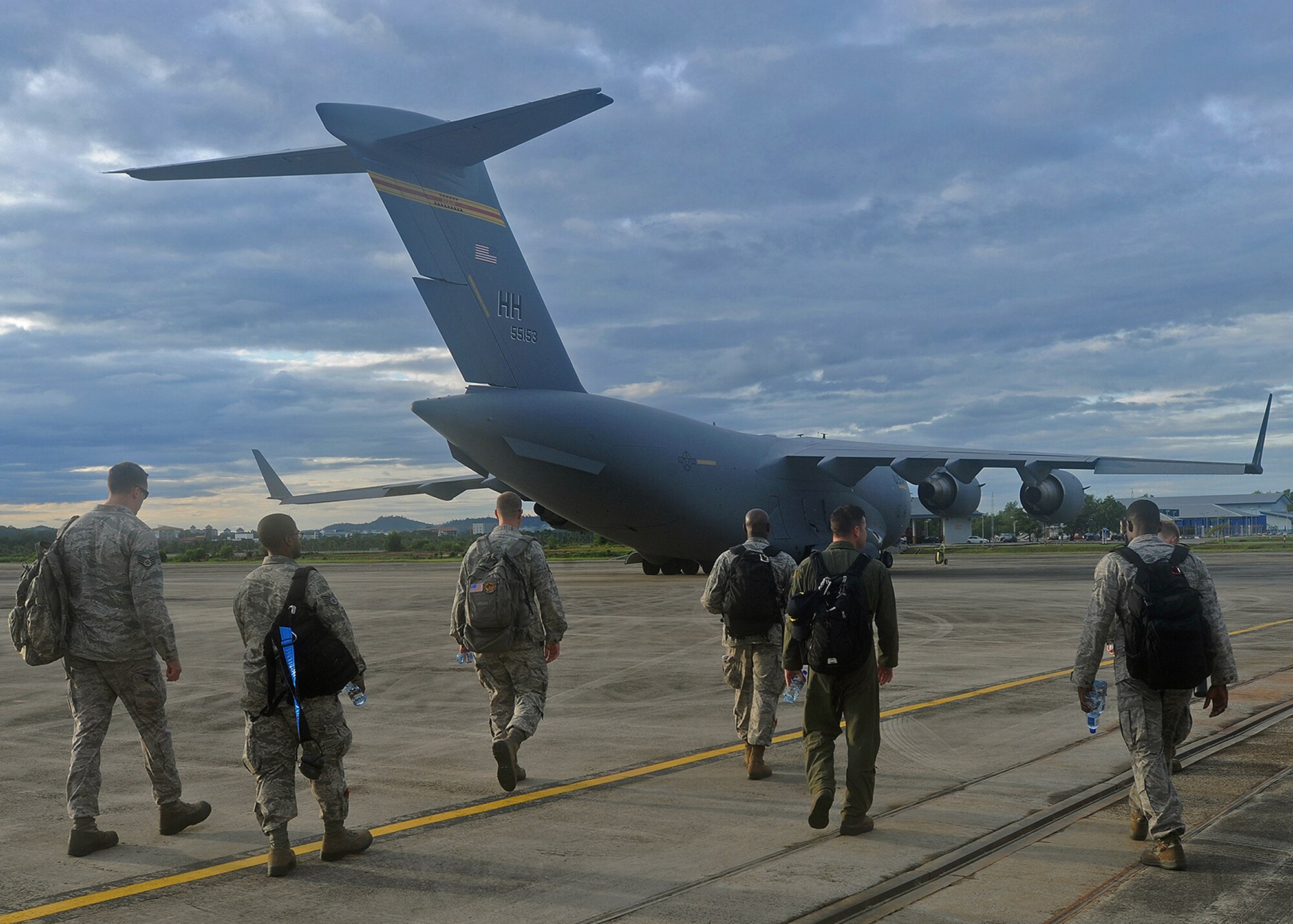 Joint Base Pearl Harbor-Hickam Airmen from the 535th Airlift Squadron prepare to board a C-17 Globemaster III at Rimba Air Base during the 4th Biennial Brunei Darussalam International Defense Exhibition, Dec. 1, 2013. JBPPH personnel will be showcasing the C-17 through static displays and aerial demonstrations during BRIDEX. The exhibition is an opportunity for networking and sharing technology with regional partners and allies, building strong multilateral relationships, increased cooperation and enhanced preparedness for disasters and other contingency operations. (U.S. Air Force photo/Master Sgt. Jerome S. Tayborn)