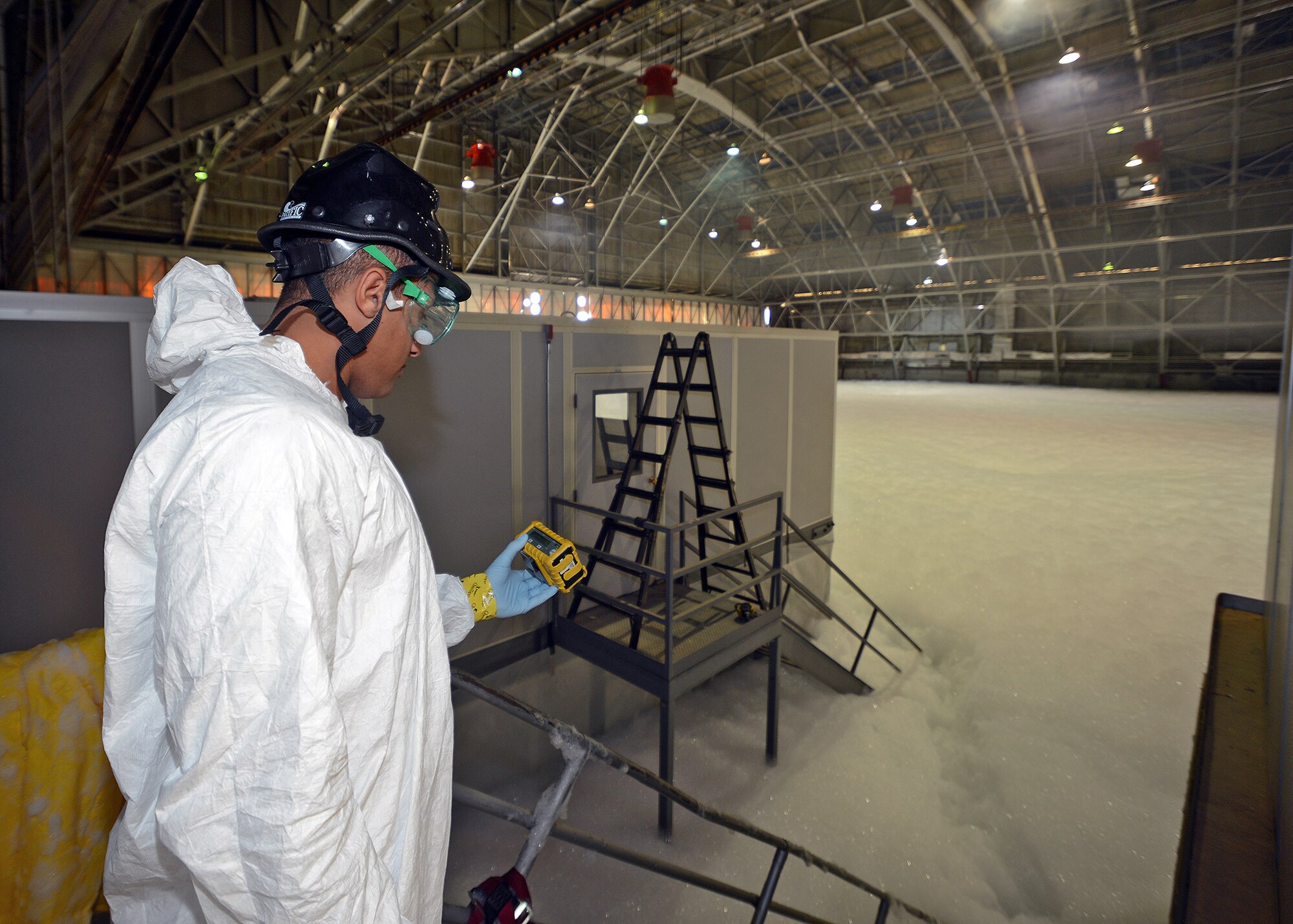 Senior Airman Andrew Travis, 412th Aerospace Medicine Squadron Bioenvironmental Engineering technician, checks oxygen levels within Hangar 1210 to see if there is any oxygen displacement after an emergency scenario exercise that involved a test of the hangar’s new fire suppression system. The 412th AMDS was just one of many organizations that were part of the exercise in order to assess all damage, investigate the cause of the incident and restore the fire suppression system to an operational status. (U.S. Air Force photo by Jet Fabara)