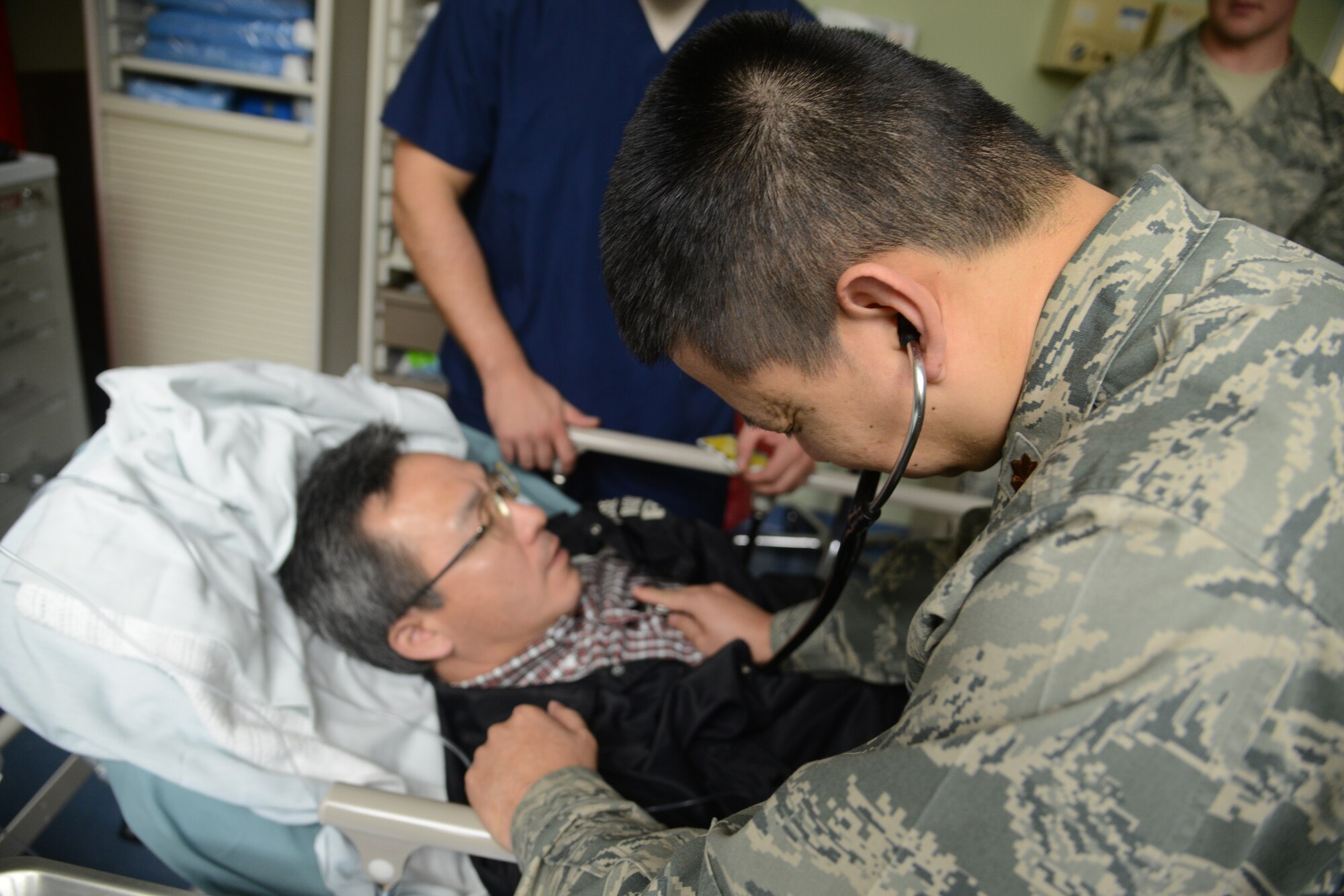 Maj. Keith Tang, a doctor with the 374th Medical Group, checks on a patient’s condition during the Tokyo Metropolitan Government disaster relief exercise at Yokota Air Base, Japan, Nov. 23, 2013.  The exercise was an opportunity for both Japanese and American forces to work together, strengthening the partnership and preparing for any future disasters.  (U.S. Air Force photo by Airman 1st Class Soo C. Kim / Released)