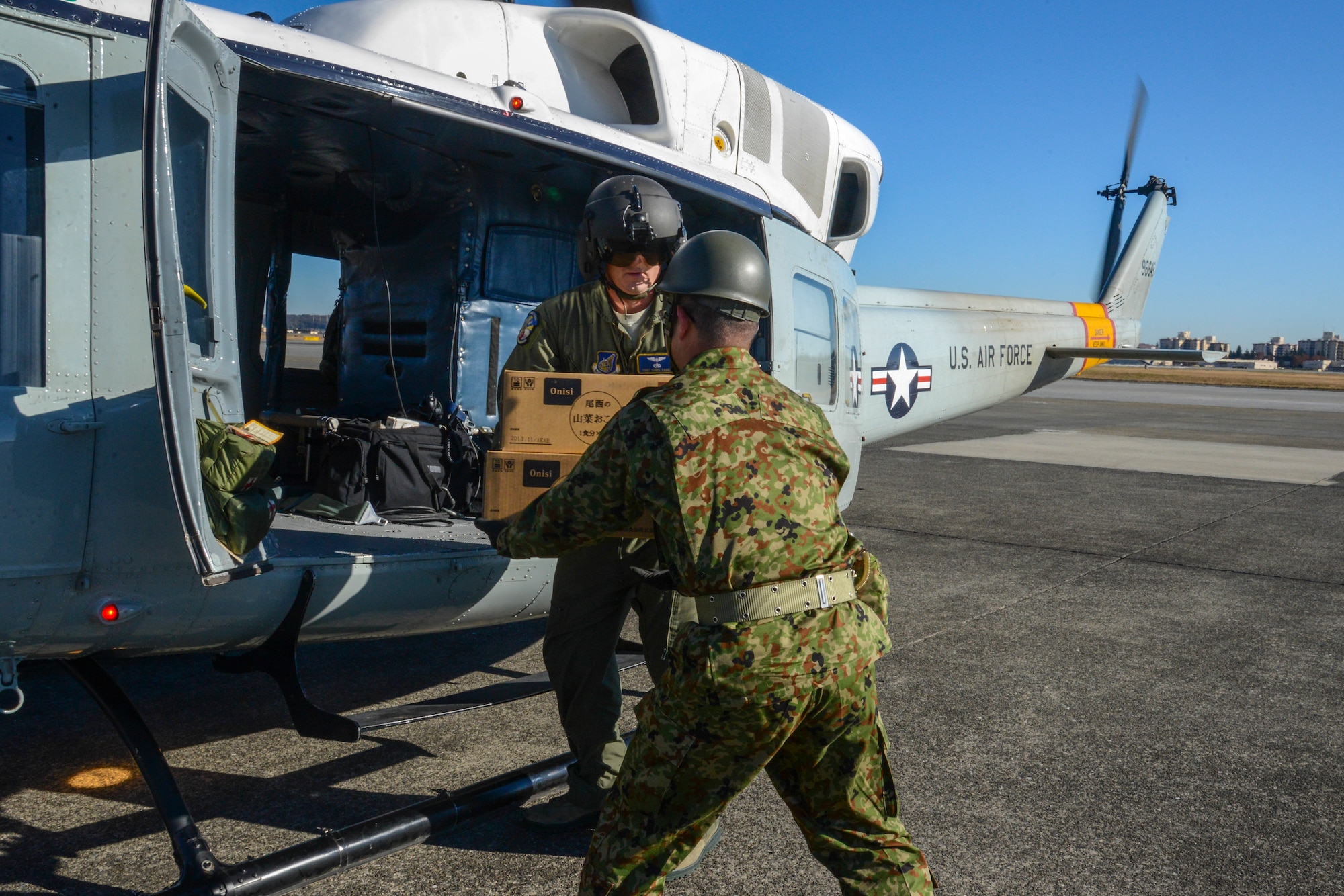 Tech. Sgt. Chris Baker, a flight engineer with the 459th Airlift Squadron, hands disaster relief supplies to a Japan Ground Self-Defense Force member during the Tokyo Metropolitan Government disaster relief exercise at Yokota Air Base, Japan, Nov. 23, 2013.  Through this unique opportunity, both American and Japanese forces strengthened their partnership and increased their preparedness for any future disasters.  (U.S. Air Force photo by Airman 1st Class Soo C. Kim / Released)
