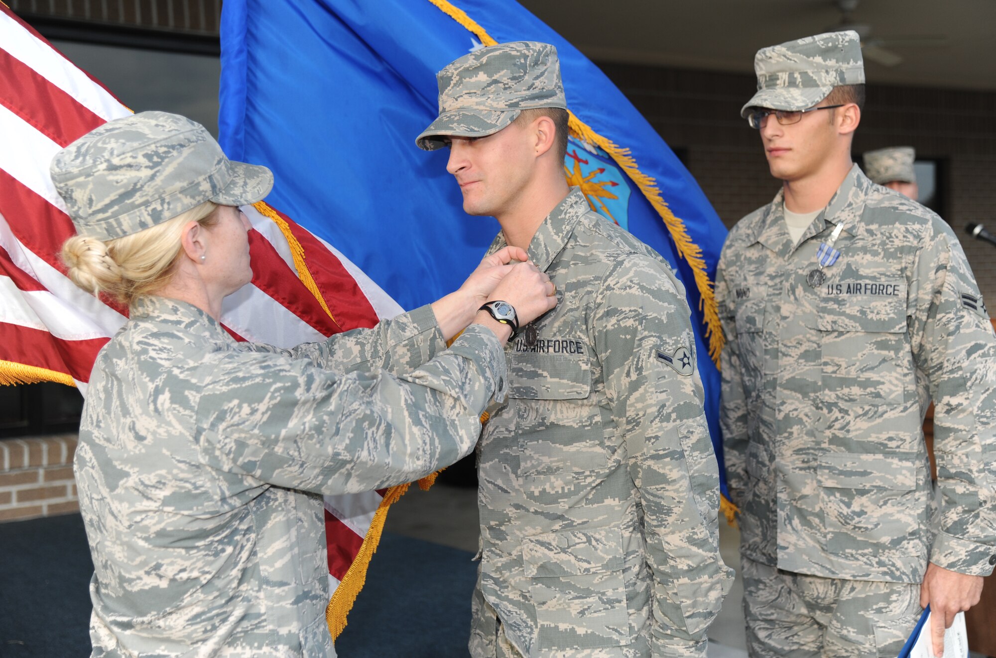 Lt. Col. Michelle Carns, 338th Training Squadron commander, presents Airman David Gaylord and Airman 1st Class Duke Marino, 338th Training Squadron, with the Air Force Achievement Medal for their life saving efforts performed in October during a dragon recognition presentation Dec. 3, 2013, behind the Levitow Training Support Facility, Keesler Air Force Base, Miss.  The event also included Col. George Tombe, 81st Training Group commander, administering the oath of enlistment to the nine Training Group’s newest Airmen promotees, as well as the announcements of the Airman of the Month and the military training flight of the Month for November.  (U.S. Air Force photo by Kemberly Groue)