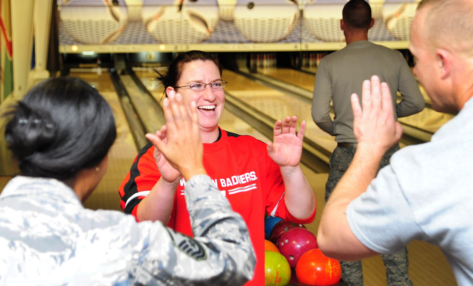 U.S. Air Force Heather sides, 509th Operations Group training manager, exchanges high-fives with U.S. Air Force Master Sgt. Lafoundra Thompson 509th OG first sergeant, and U.S. Air Force Master Sgt. Clinton Dalton, during a fundraiser for the Combined Federal Campaign at the Stars and Strikes Bowling Alley on Whiteman Air Force Base, Mo., Nov. 22, 2013. More than $900 was raised for the CFC during the fundraiser. Each year, the CFC allows Service members and civilians to make monetary contributions to their choice of more than 1,800 agencies, charities and organizations. CFC ends Dec. 15, 2013. (U.S. Air Force photo by Staff Sgt. Nick Wilson/Released)