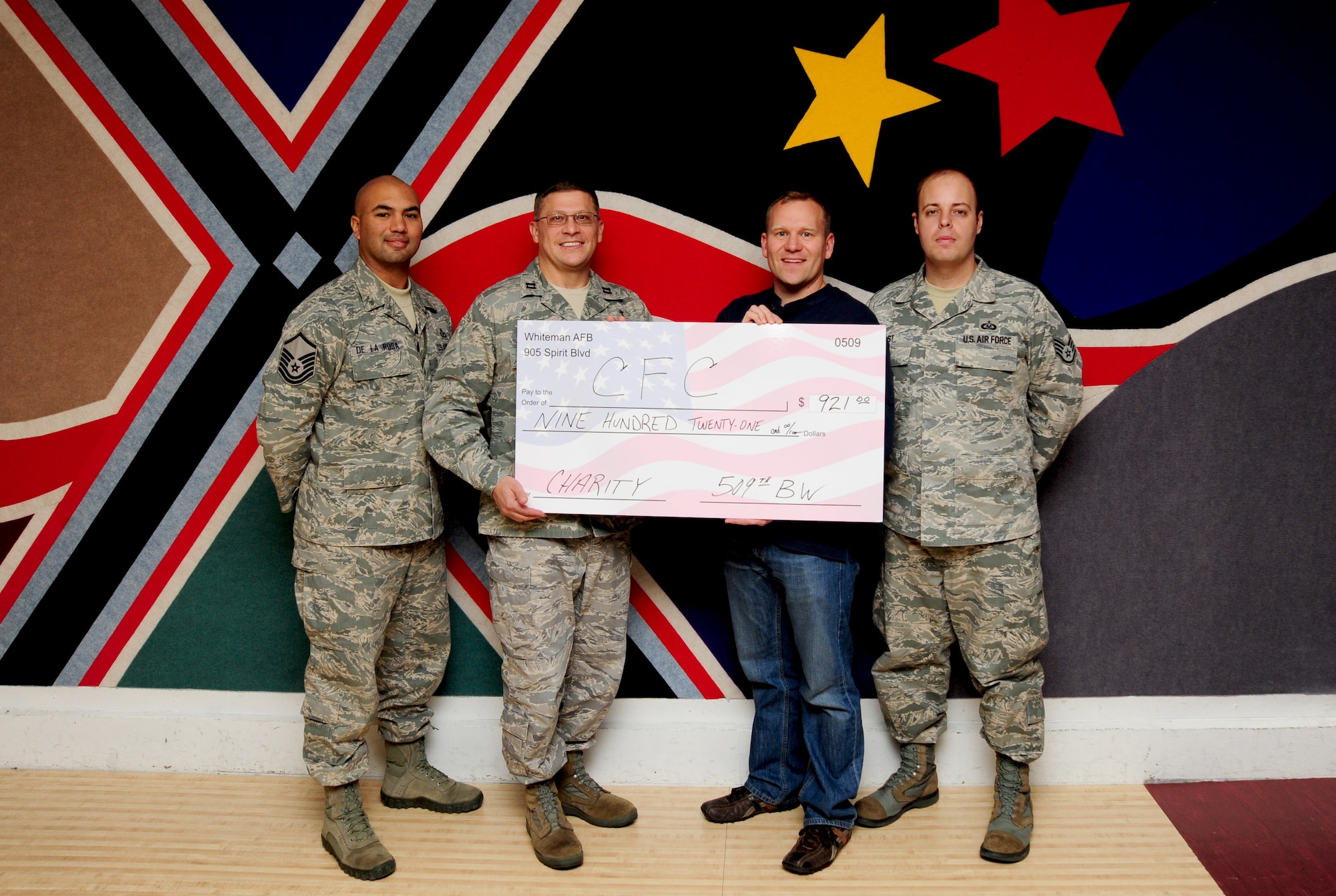 Base representatives for the Combined Federal Campaign are presented with a giant check for $921 at the Stars and Strikes Bowling Alley on Whiteman Air Force Base, Mo., Nov. 22, 2013. The money was raised as part of a bowling fundraiser toward the CFC.  Each year, the CFC allows Service members and civilians to make monetary contributions to their choice of more than 1,800 agencies, charities and organizations. CFC ends Dec. 15, 2013. (U.S. Air Force photo by Staff Sgt. Nick Wilson/Released)