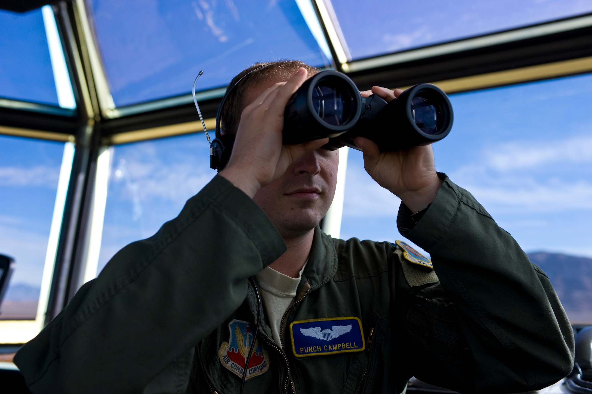 U.S. Air Force Capt. Todd Campbell, 59th Test and Evaluation Squadron supervisor of flying, looks for aircraft through binoculars in the air traffic control tower Nov. 27, 2013, at Nellis Air Force Base, Nev. The supervisor of flying main responsibility is to coordinate what needs to be done between pilots and aircrew. (U.S. Air Force photo by Airman 1st Class Christopher Tam)