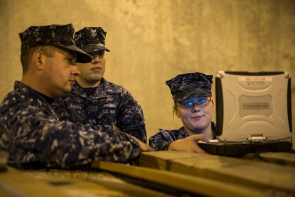 Navy Munitions Command Unit Charleston quality assurance inspectors review a stand operating procedure document on a computer while checking the condition of the inside of a magazine Nov. 21, 2013, at Joint Base Charleston – Weapons Station, S.C. The quality assurance inspectors make sure the magazines are maintained year round and were given a satisfactory during the Explosive Safety Inspection on Nov. 21. (U.S. Air Force photo/ Senior Airman Dennis Sloan)