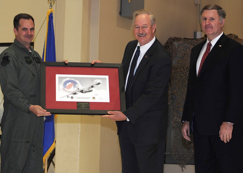 U.S Air Force Col. Sean Farrell, 27th Special Operations Group commander, receives a commemorative picture of a MC-130J from Ray Fajay, director of U.S. Government Air Mobility Development, and Robert Lowe, director of Air Mobility Special Operation Forces Programs, Nov. 26, 2013 at Cannon Air Force Base, N.M.  The 522nd Special Operations Squadron achieved the 1 millionth hour in the MC-130J in April 2013.  The flight hours were tracked over a 17 year period and were contributed by 13 countries flying the AC-130J. (U.S. Air Force photo/Senior Airman Ericka Engblom)