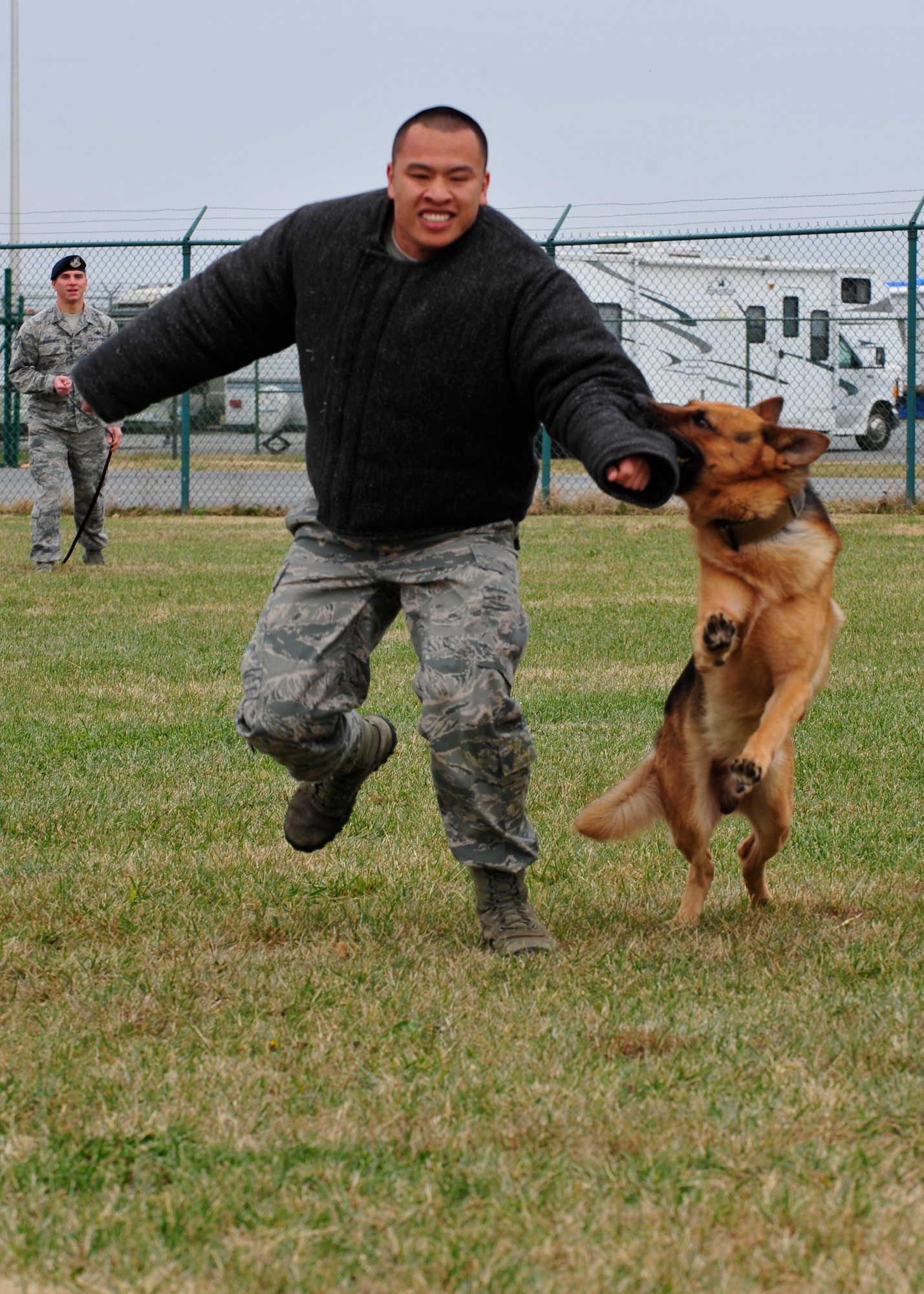 Staff Sgt. Jason Spangenberg , 436th Security Forces Squadron military working dog handler, watches while his military working dog, Rico, take down Staff Sgt. Thanh Nguyen, 436th SFS military working dog handler, Dec. 2, 2013, at Dover Air Force Base Del. Spangenberg received the Colonel Billy Jack Carter award.  (U.S. Air Force photo/Airman 1st Class William Johnson)