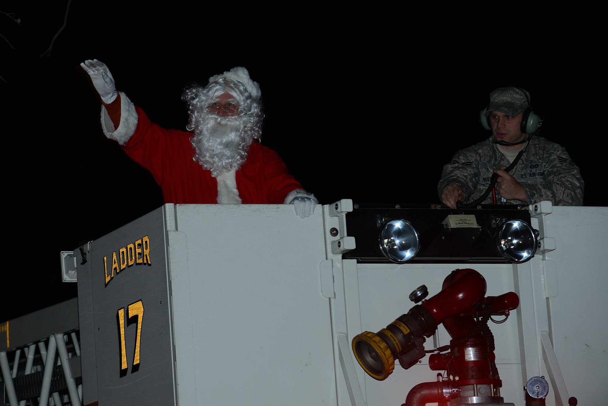 Jim Wyatt, Air Combat Command executive secretary to the chaplain commander, arrives dressed as Santa Clause aboard a fire truck during the Langley tree-lighting ceremony at Langley Air Force Base, Va., Dec. 3, 2013. After the ceremony, Wyatt greeted children inside the chapel annex while portraying the Christmas character. (U.S. Air Force photo by Airman 1st Class Kimberly Nagle/Released)